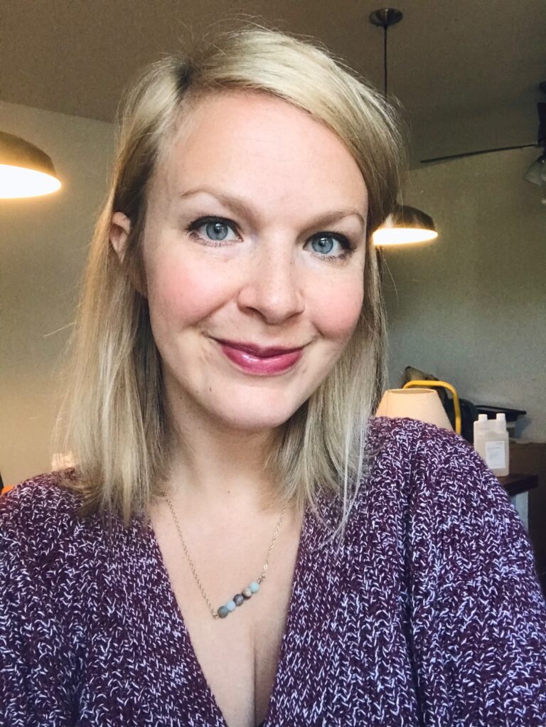 A blond woman in her 30s wearing a cardigan